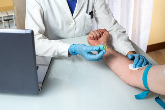 Laboratory technician in a blood test to a patient / Blood test at the medical examination 