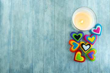 Postcard for Valentine's day. Multicolored hearts and a burning candle