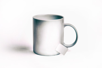 white cup and bag of tea. isolated on white background. Mockup for designs. toned