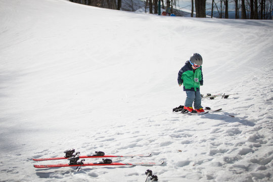 Child on snow covered landscape learning to ski