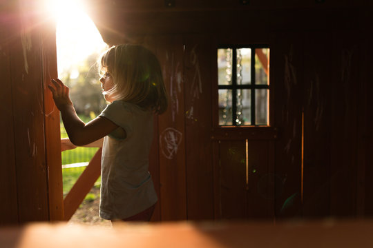 Girl drawing on playhouse walls with chalk