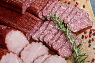 Set of cold cuts on a wooden board. Mix of sausages
