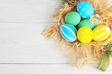 Easter eggs in the nest on rustic white background