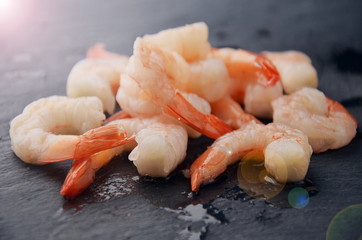 Boiled king shrimps on a black stone table