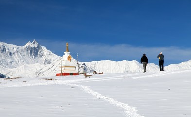 buddhist stupa with two tourists in Annapurna area