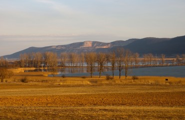 Sunset over the lake and field in spring