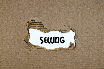 The word selling appearing behind torn paper