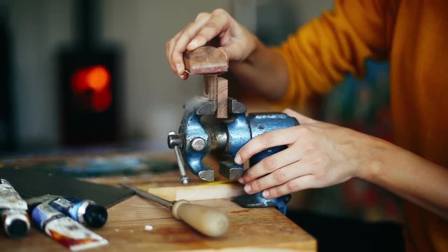 Female carpenter hands sanding wood on clamp