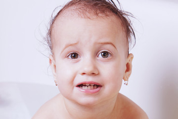 Baby girl playing with water in the bath