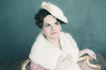 Transgender woman retro 1920s fashion sitting on sofa.