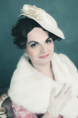 Transgender woman retro 1920s fashion sitting on sofa.