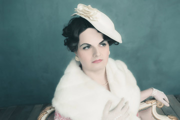 Transgender woman retro 1920s fashion sitting on sofa.