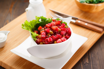 vinaigrette on a white plate, wooden board and background.