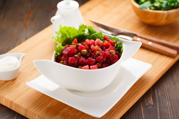 vinaigrette on a white plate, wooden board and background.