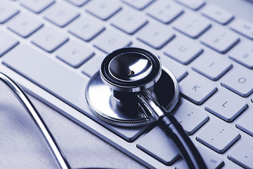 Close-up of a stethoscope on the keyboard of a computer. Technology and medicine.