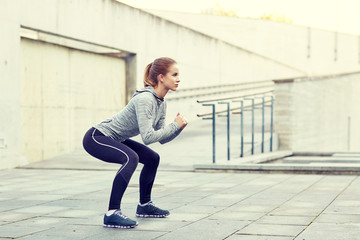 woman doing squats and exercising outdoors