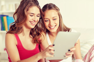 Fototapeta na wymiar happy friends or teen girls with tablet pc at home