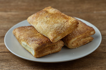 Delicious puff pastry with apples on a wooden background