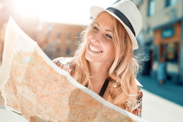 Happy young woman using a city map