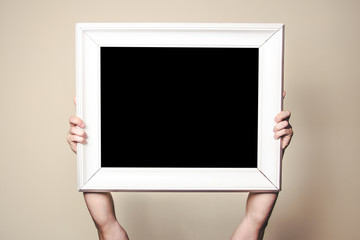 Male hands holding empty copy space wooden frame for graphic design.