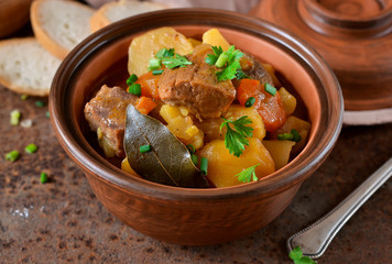 Stew with vegetables and potatoes on an old grunge background