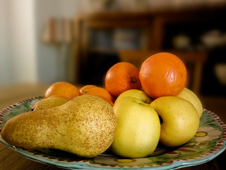 Oranges and pear closeup on wooden vintage table.