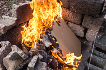 Obraz premium Burning Newspaper or Cardboard in Burning Pit with Flames