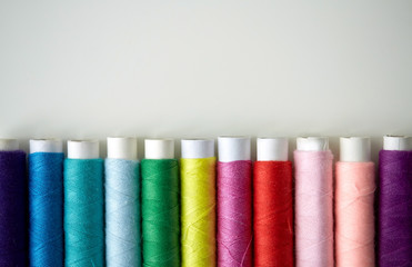 row of colorful thread spools on table