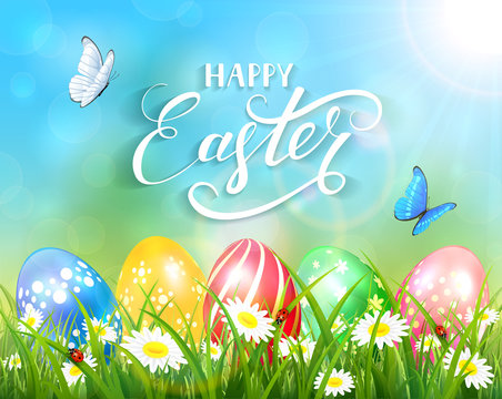Happy Easter on blue background and eggs on grass