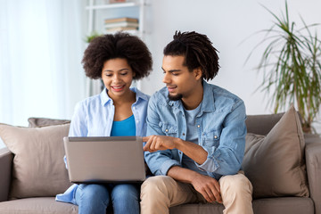 smiling happy couple with laptop at home