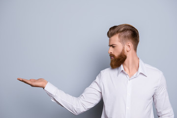 Portrait of serious confident bearded man showing copy space on hands