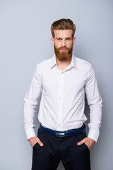 Portrait of serious confident  bearded man in formalwear holding hands in pockets