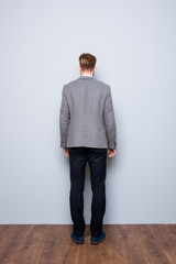 Full-length back view portrait of smart  confident  bearded man in formalwear