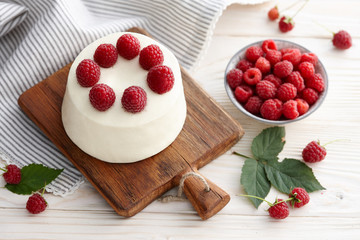 Raspberry mousse cake with fresh raspberries on wooden board