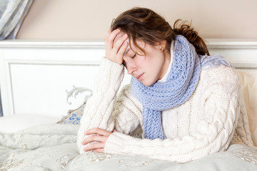 Flu or cold. Closeup top view image of frustrated young woman with blue scarf and suffering from...