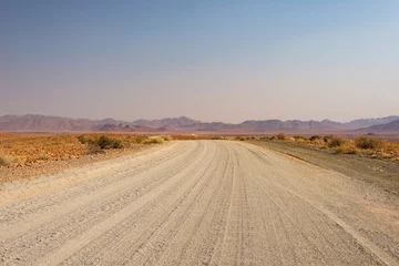 Gravel 4x4 road crossing the colorful desert at Twyfelfontein, in the majestic Damaraland Brandberg, scenic travel destination in Namibia, Africa. © fabio lamanna