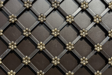 Forged flowers in a Golden hue on the fence