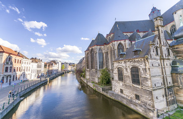 Naklejka premium GENT, BELGIUM - MARCH 2015: Tourists visit ancient medieval city. Gent attracts more than 1 million people annually