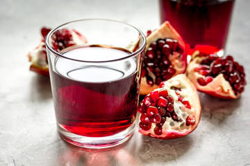 fresh pomegranate with juice in glasses on kitchen background