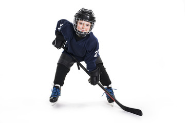 Young boy in ice hockey gear against white
