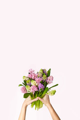 A bouquet of hyacinths in hands. Spring background