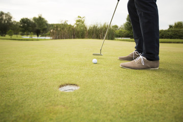 Obraz premium Young man playing golf on the golf course
