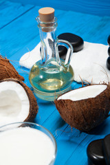 Coconut oil and stones for a massage on a blue wooden background