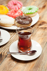 Cup of tea and donuts on a wooden background