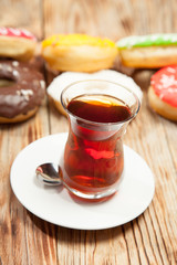 Cup of tea and donuts on a wooden background