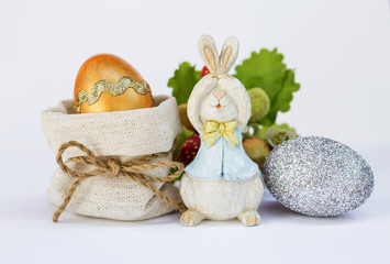 Obraz na płótnie Canvas Easter concept, gold and silver Easter egg with wooden bunny 