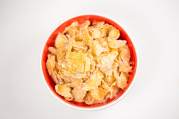 bowl of sugar-coated corn flakes isolated on white.