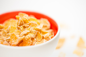 bowl of sugar-coated corn flakes isolated on white.