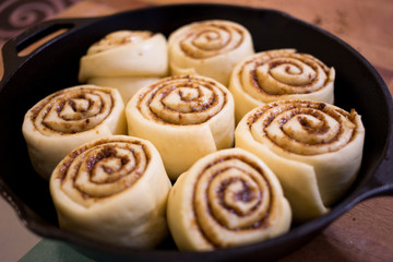 Homemade cinnamon rolls dough fermentation in iron pan.