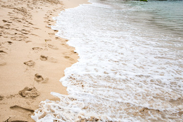 Soft blue ocean wave on sandy beach in Kenting, Taiwan.